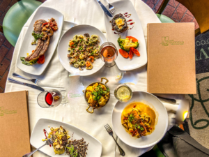 alt="a table topped with plates of food and drinks in Osteria Panevino Restaurant"