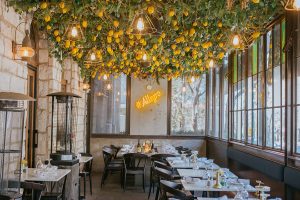 alt="Interior of a restaurant called allegro with lemons hanging from the ceiling"